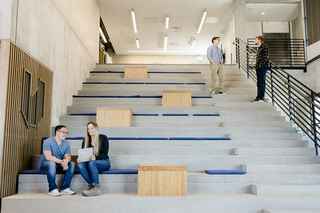 employees talking in the Wells office on the stairs